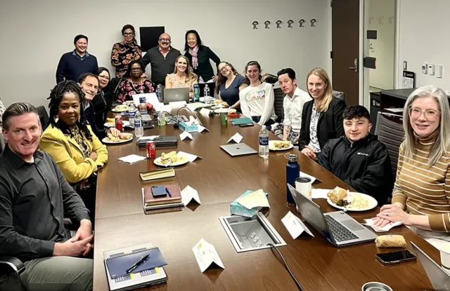 Group of RSSL staff and students gathered around a table.